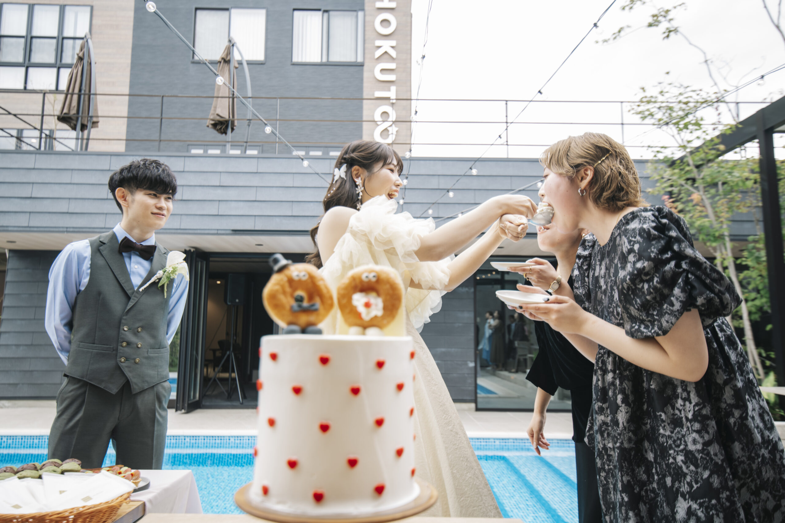 プールサイドのウェディングケーキと新郎新婦